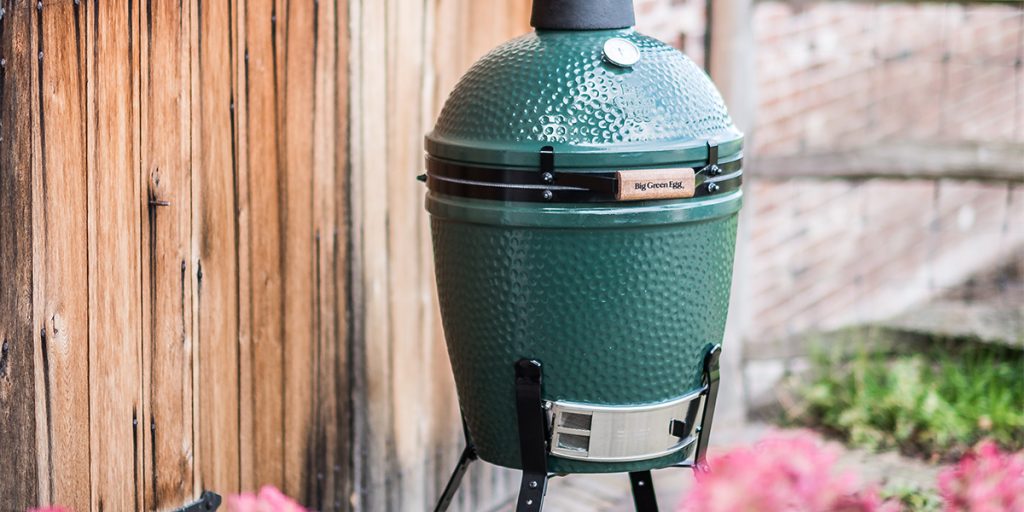 ein Big Green Egg Grill Medium in einem Nest im Garten